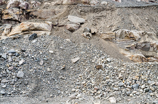 Layered rock face, gravel and sand