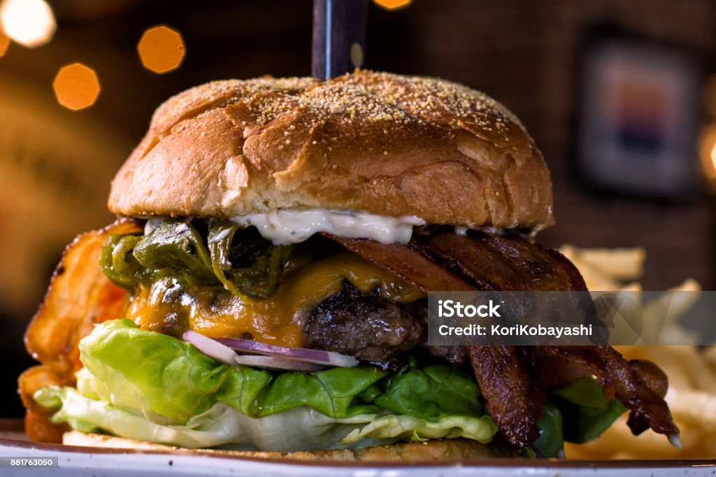 Bacon Green Chile Burger Akaushi beef topped with green chile, applewood smoked bacon, onions, lettuce, tomato, green chile infused mayo, served on a  brioche bun Green Chili Pepper Stock Photo