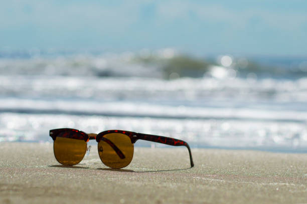 istock Sunglasses on Sand by the Sea 881768960