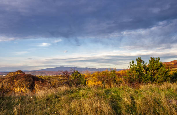 istock countryside with grassy hills at autumn sunset 881769120