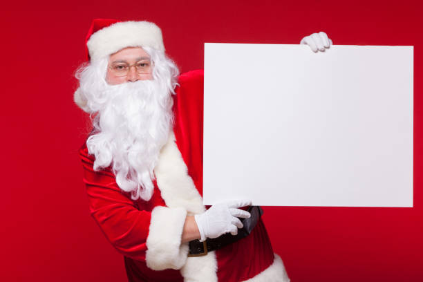 istock Santa Claus pointing in blank advertisement banner isolated on red background with copy space 881770034
