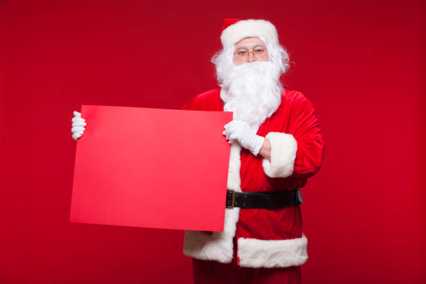 istock Santa Claus pointing in blank advertisement banner isolated on red background with copy space red leaf 881770426