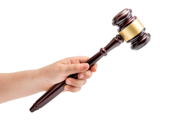 istock Child hand holding judge's gavel. Isolated on white. 881770442