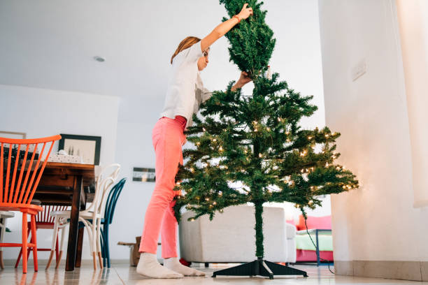 Siblings Putting up a Christmas tree Siblings Putting up an artificial Christmas tree hot mexican girls stock pictures, royalty-free photos & images
