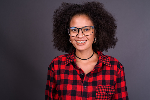 Studio Shot Of Young African American Woman Of Mixed Race Against Gray Background