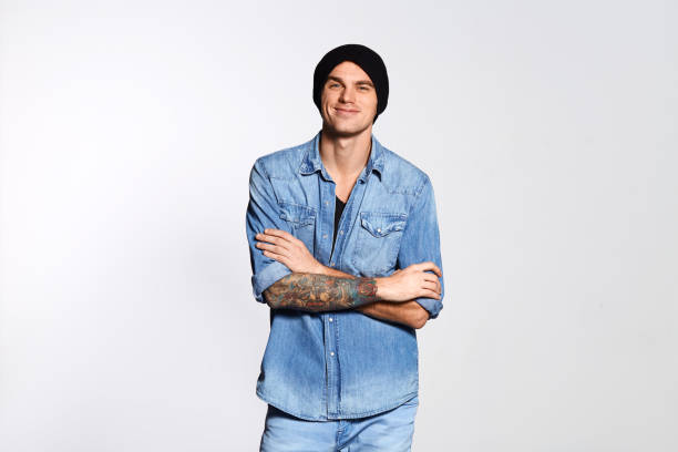 istock Handsome man has arms crossed and looking at camera on white wall 881776230