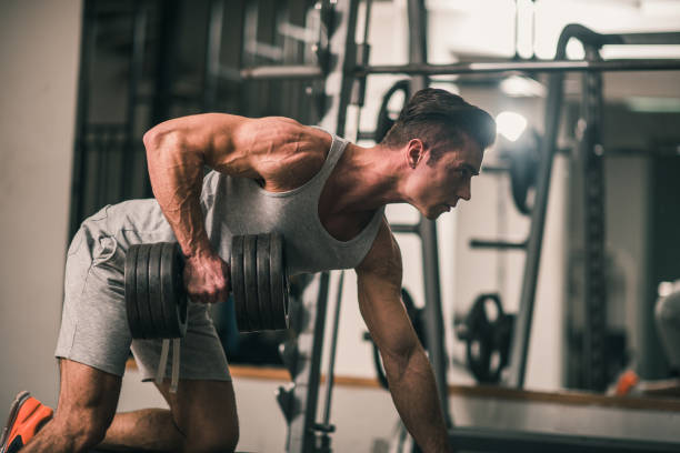 istock Man in the gym exercising with a hand weight 881789106
