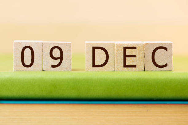 istock Wooden cube shape calendar for DEC 9 on green book, table. 881791330