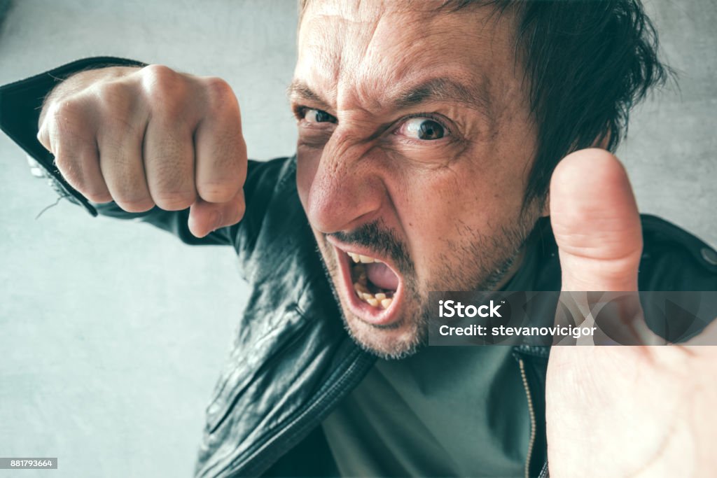 Aggressive man punching with fist Aggressive man punching with fist during the fight, from victim's point of view. Violence and crime concept. Fighting Stock Photo