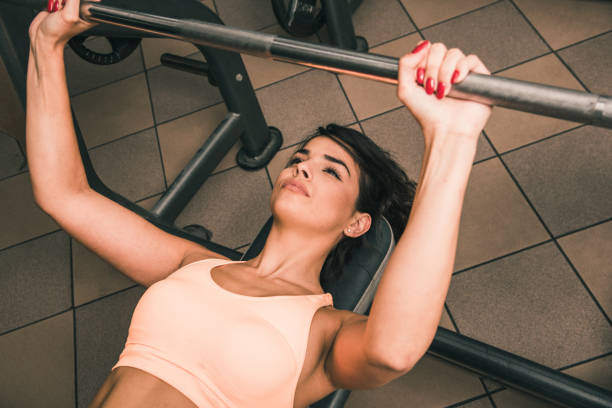 istock Woman exercising on a weight bench 881793722