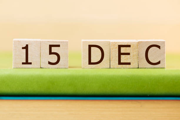 istock Wooden cube shape calendar for DEC 15 on green book, table. 881793914