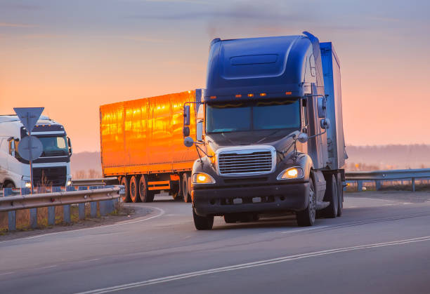 istock trucks goes on highway on sunset 881799806