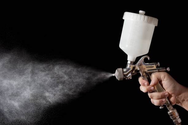 Close up of a spray paint gun with black background