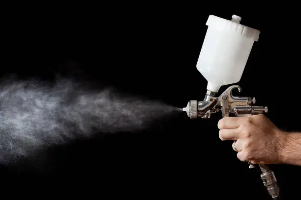 Photo of Close up of a spray paint gun with black background