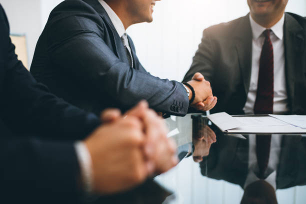Business people shaking hands, finishing up a meeting Business people shaking hands, finishing up a deal lawyer stock pictures, royalty-free photos & images