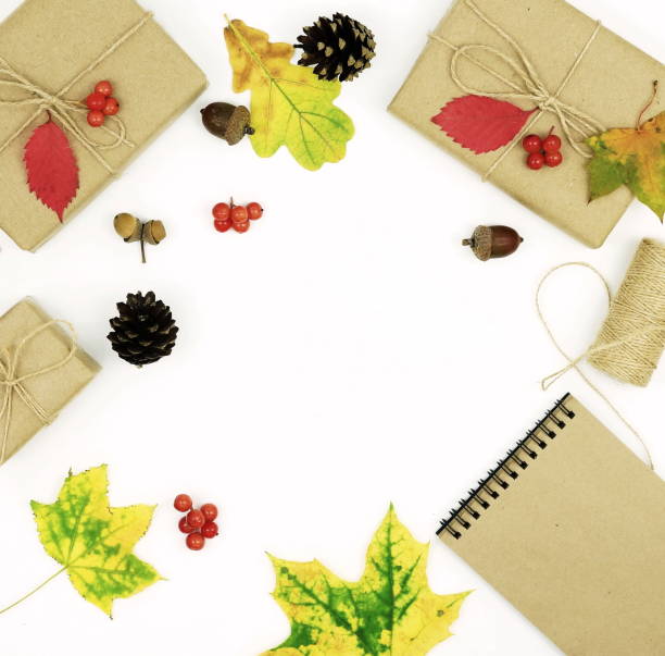 istock Autumn composition with leaves, gifts packed in craft paper, notepad for text on white background.Top view. Flat lay. Copy space 881818692