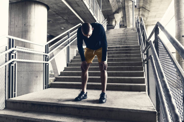 zmęczony mężczyzna biegacz odpoczywa po treningu. - breathing exercise jogging exercising relaxation exercise zdjęcia i obrazy z banku zdjęć