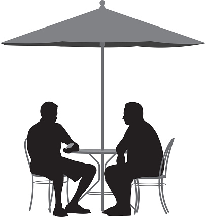 Vector silhouette of two men sitting at a table under an umbrella.