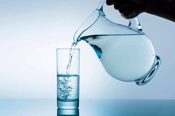istock woman pouring water from jug 881848738