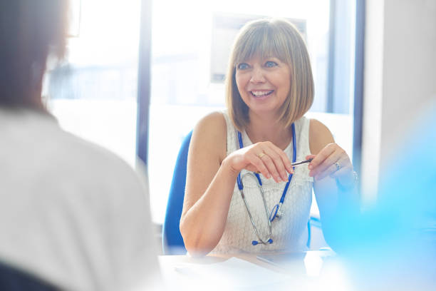 It's good news Female doctor in consultation with patient in her office doctor general practitioner stock pictures, royalty-free photos & images