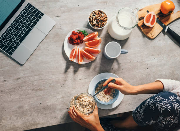 temps de matin - femme prépare le petit déjeuner sain - cereal breakfast granola healthy eating photos et images de collection