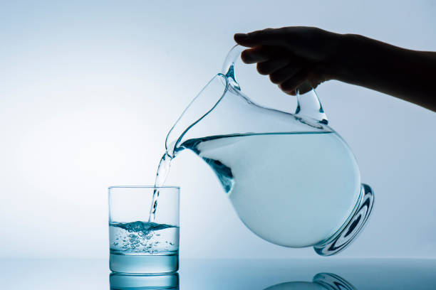 istock woman pouring water from jug 881850128