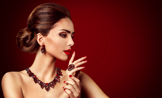 Fashion Model Red Stone Jewelry, Woman Retro Makeup and Red Gemstones Ring Earrings Necklace, Beautiful Girl looking side over red background