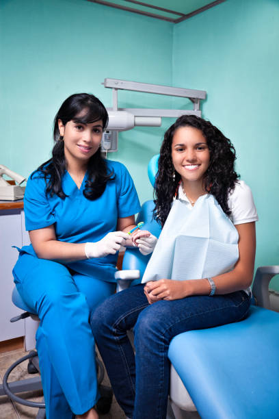 istock Dentist teaching toothbrush techniques to young woman patient 881852808