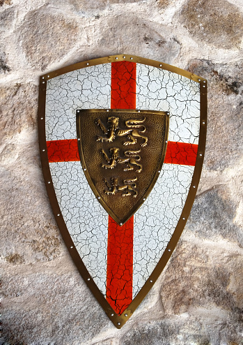 Middle age metallic shield on a stone wall