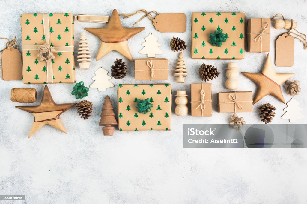 Top view of brown boxed Christmas presents Christmas arrangement, brown present boxes with embossed fir trees, pine cones, brown gift tags, wooden decorations, jute twine, top view, on the light background, copy space for text Arranging Stock Photo