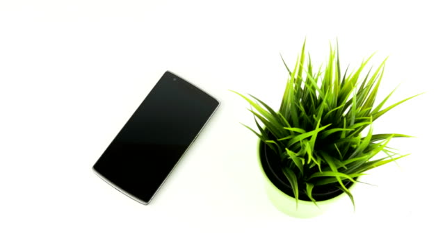 Smart Phone Next To Green Grass In Ceramic Pot Panning Movement