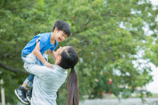 istock Cheerful mom picks up preschool age son 881881358