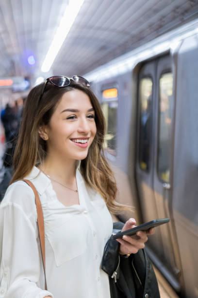 istock Beautiful female commuter prepares to board subway train 881881562