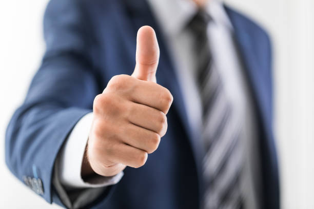Business man shows thumb up sign gesture.
