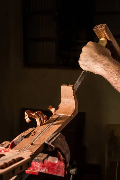 Photo of Luthier making a neck of acoustic guitar