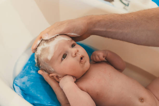 istock Unrecognizable father bathing her son in white small plastic bat 881886416