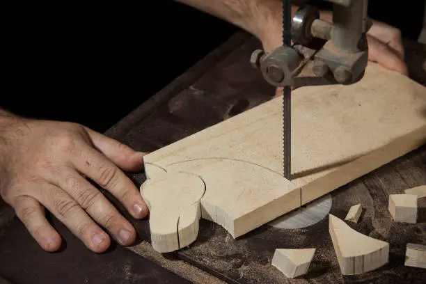 Photo of A craftsman cutting a wood head horse with bandsaw