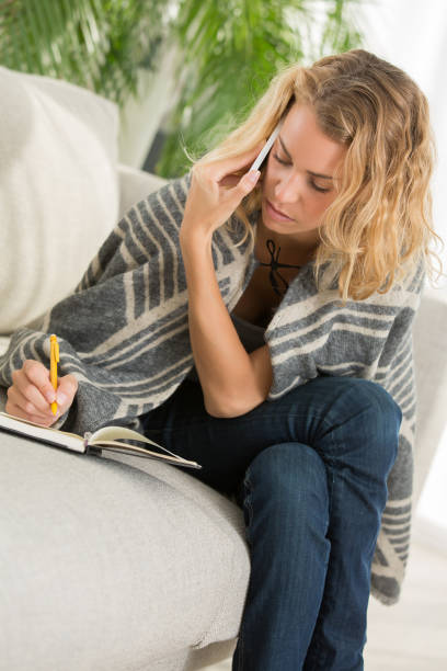 istock woman making appointment by phone and writing it on schedule 881897164