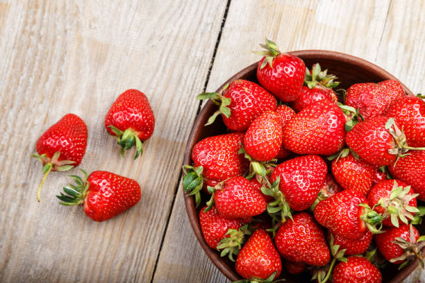 istock Fresh strawberry in a clay plate  on wooden table 881906654