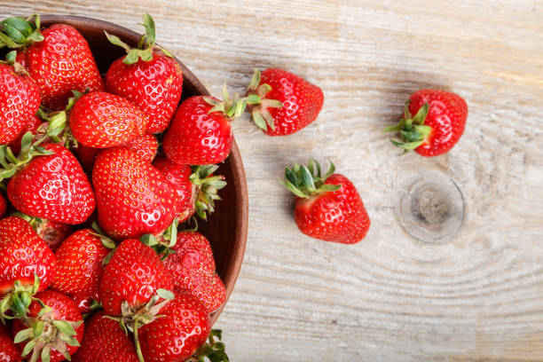 istock Fresh strawberry in a clay plate  on wooden table 881906656