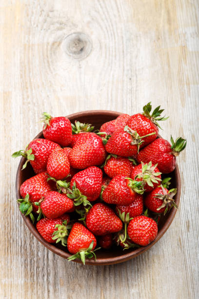 istock Fresh strawberry in a clay plate  on wooden table 881906684