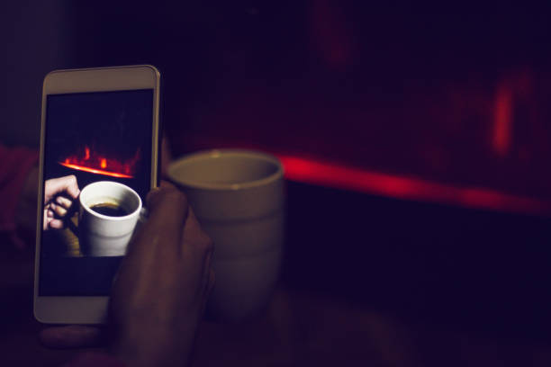 Female holding mobile phone by the fireplace