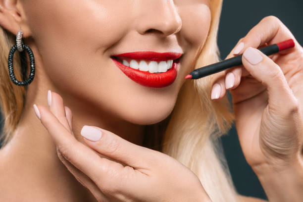 chica de cabello rubio con visagiste aplicar lápiz labial - lip liner fotografías e imágenes de stock