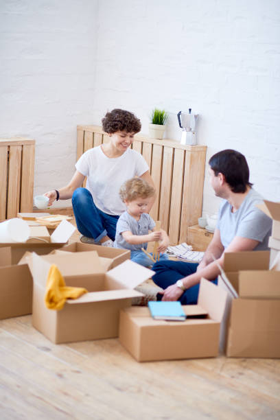 istock Friendly family unpacking boxes together 881936324