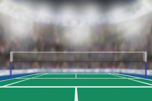 Low angle view of badminton arena with sports fans in the stands and copy space. Focus on foreground with deliberate shallow depth of field on background. Fictitious arena created in Photoshop.