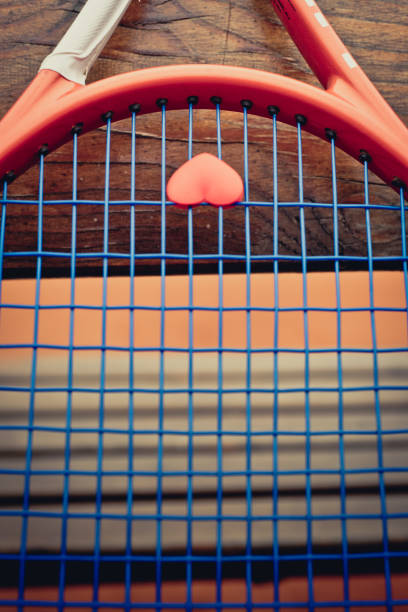 raquette de tennis avec un cœur en forme de string antivibratoire - racket string photos et images de collection