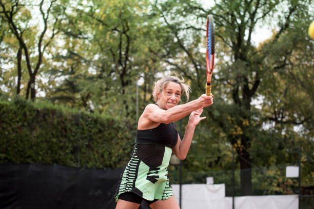 istock Woman Swinging with a Tennis Racket 881941406