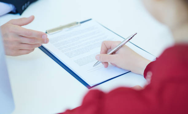 istock Woman signing the insurance contract document. Selective focus image on sign a contract. 881942162