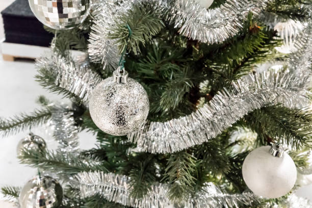istock Closed up shiny silver ball on decorative Christmas tree with tinsel garland, glitter balls for interior seasonal greeting. 881952814