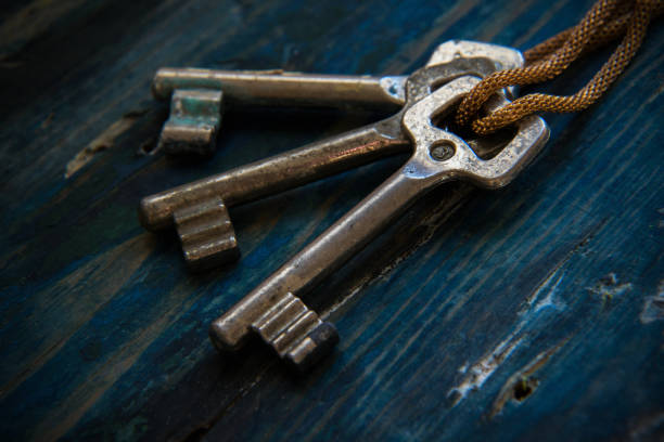 istock Three antique keys on wooden table 881959506